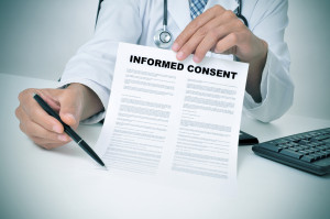 a doctor in his office showing an informed consent document and pointing with a pen where the patient must to sign